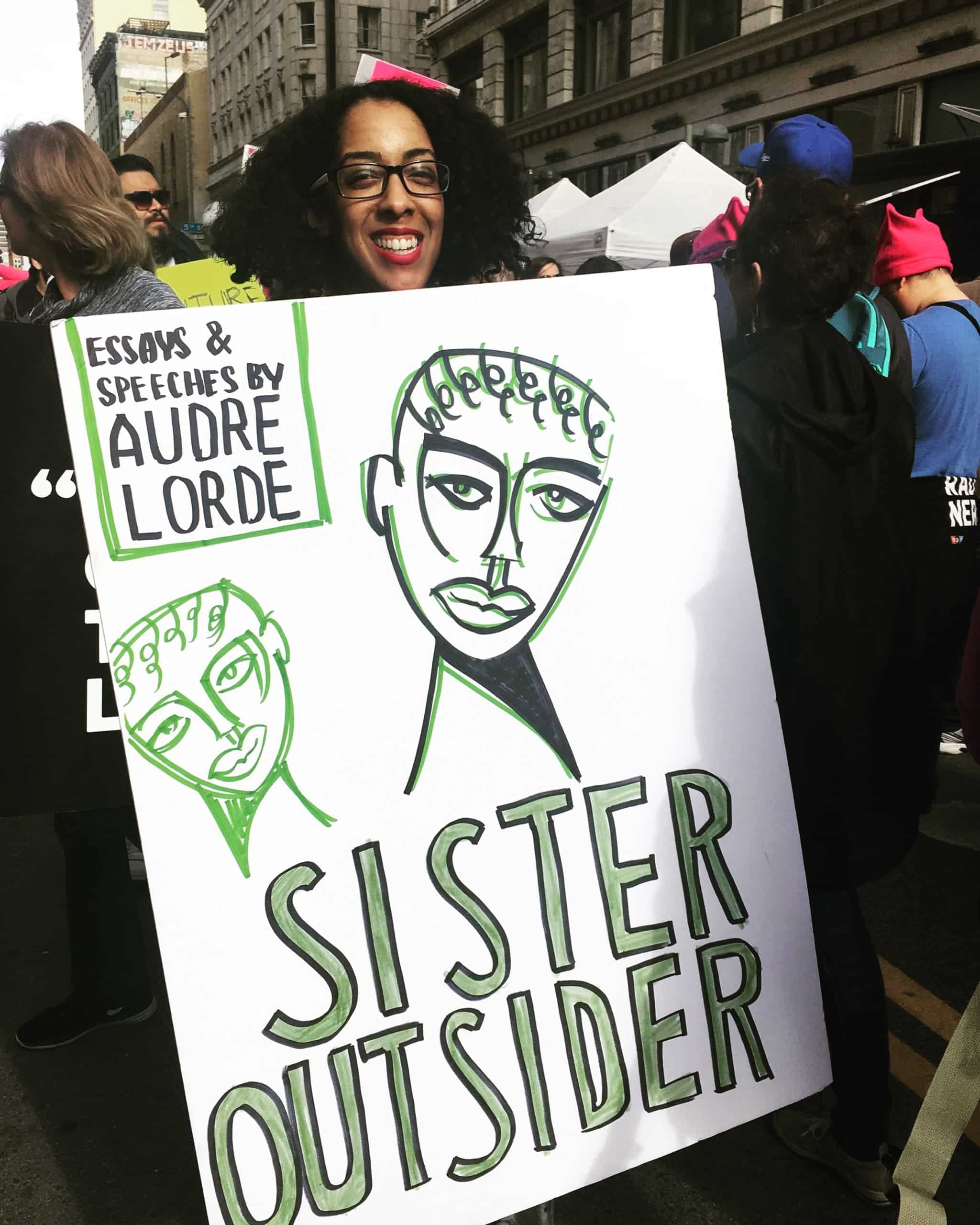 Graduate Martine McDonald holding a protest sign during the women's march
