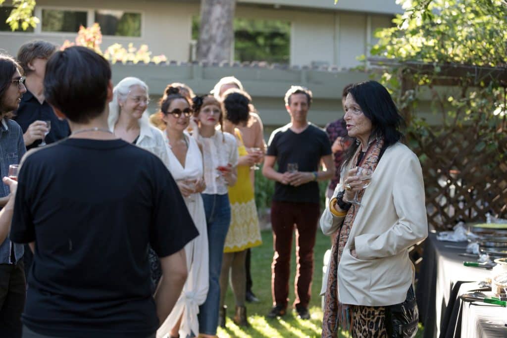 Anne Waldman standing with a group of visiting Summer Writing Program faculty in an outdoor setting