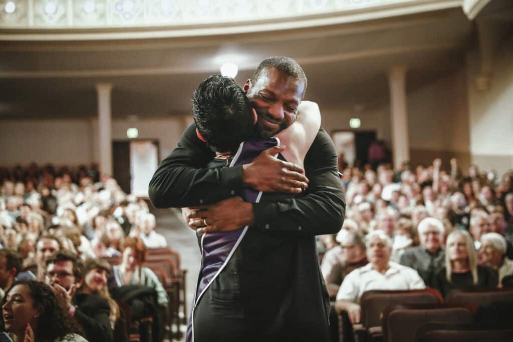 Faculty Ramon Parish hugs graduating student