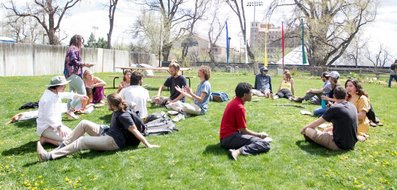 Naropa students sitting in groups on the Naropa Green
