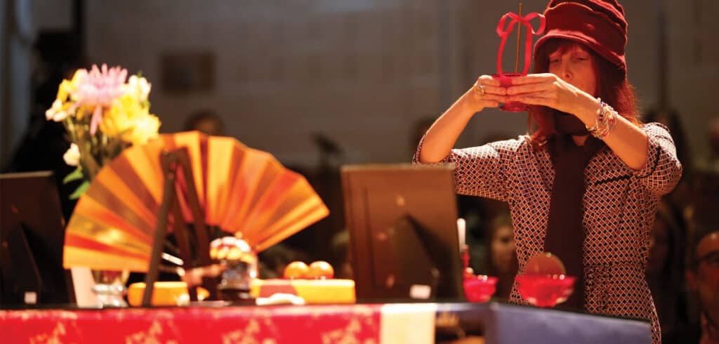 Carole Clements holding an object on an altar