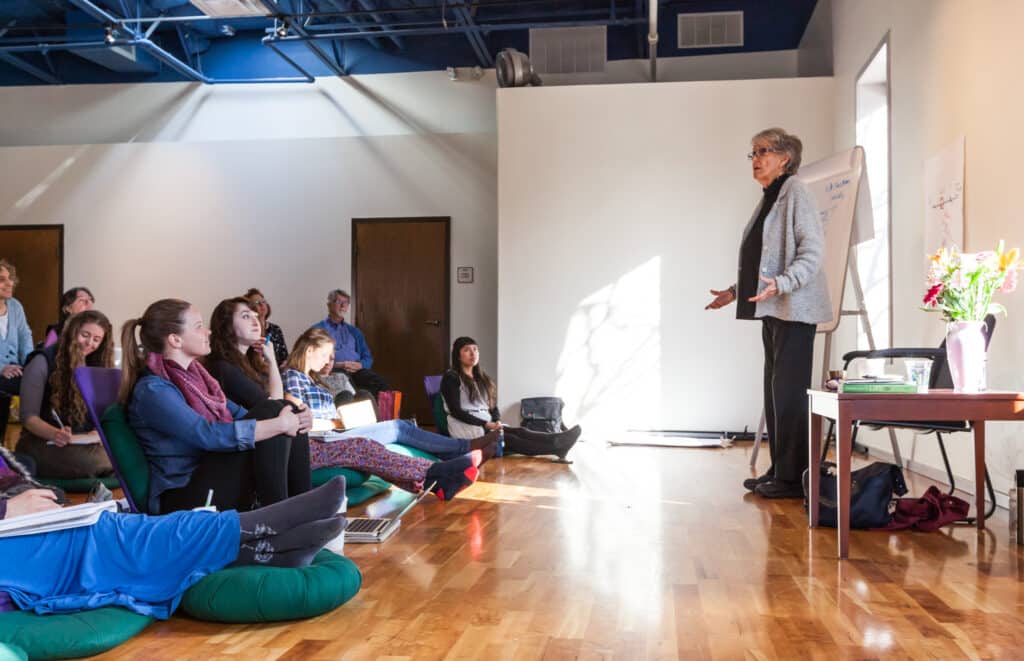 Joanna Macy speaking to students in a classroom