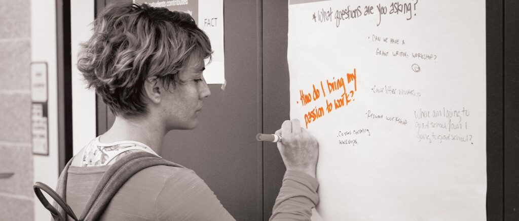 A person writing a message on a canvas