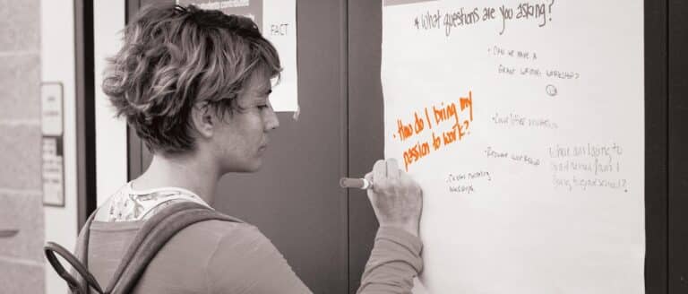 A person writing a message on a canvas
