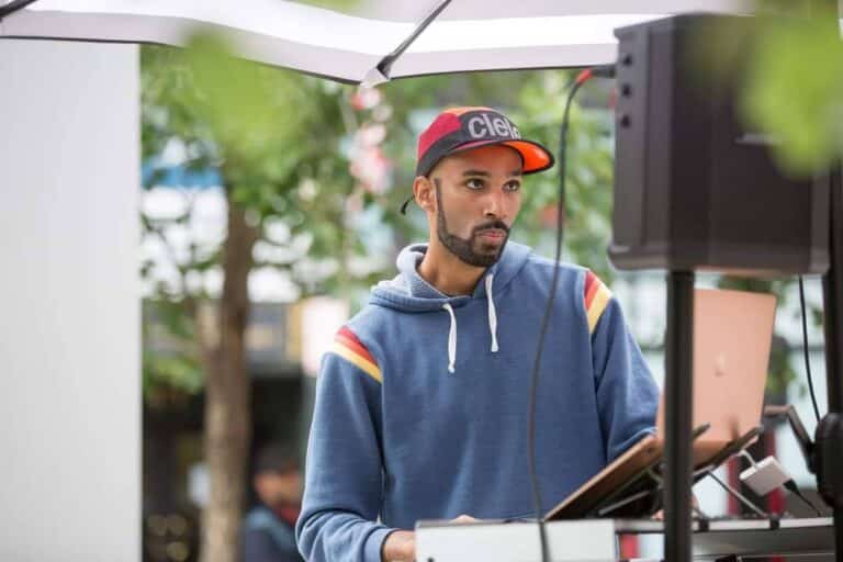 Edward standing outside in front of speakers and a DJ console.