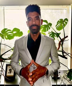 Anthony Gallucci stands in front of plants near a window in his office.