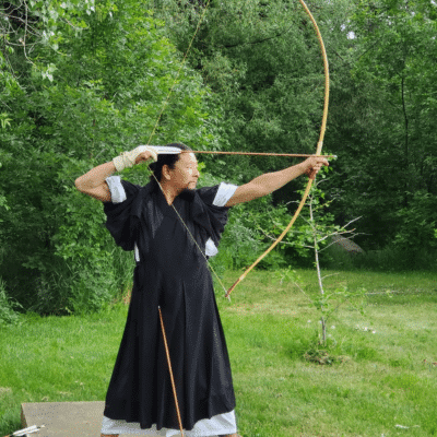 A man in a black robe holding a bow and arrow