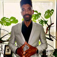 Anthony Gallucci stands in front of plants near a window in his office.